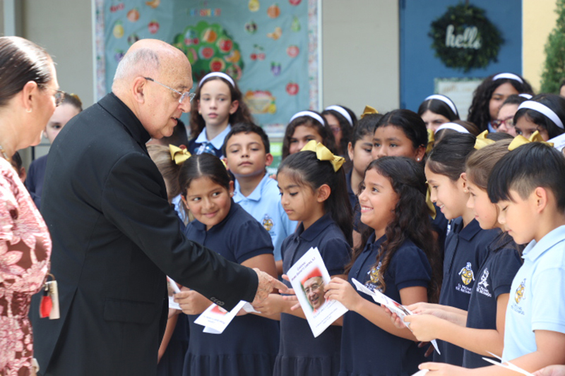 EL cardenal peruano, Pedro Barreto conversa con los niños del coro de la escuela St. Michael the Archangel en Miami que lo recibieron con canciones en ingles y en español, el 25 de agosto de 2025. El Cardenal Barreto con su delegación peruana visitaron otras dos escuelas, St. Theresa en Coral Gables y St. James en North Miami. A la extrema izquierda, Lisette Reina-Naranjo, directora de la escuela, observa.