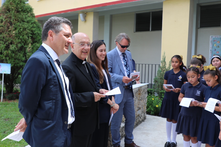 El Cardenal Pedro Barreto, arzobispo emérito de Huancayo, Perú, (segundo desde la izquierda) agradece a los niños del coro de la escuela St. Michael the Archangel que lo recibieron cantando en español, el 25 de agosto de 2025. Con él, la delegación peruana que lo acompaña, desde la izquierda, Miguel Cruzado, Sofía Hochschild y Geoff Cocksworth.