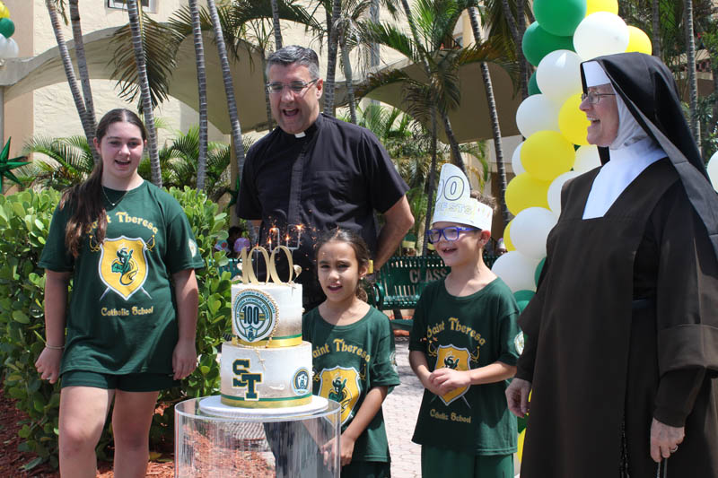 St. Theresa School students Valentina Alvarez, Olivia Portoblanco, and Peter Darley accompanied by Father Manny Alvarez and Carmelite Sister Rosalie Nagy sing "Happy Birthday" during the school's centennial birthday bash celebrated Sept. 15, 2025.