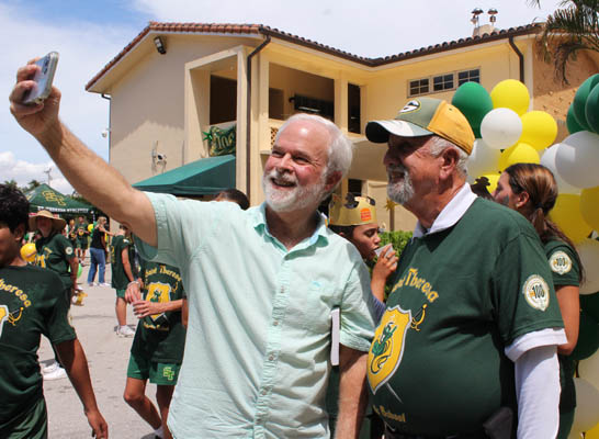 Kirk Menendez, former commissioner of Coral Gables, whose children attended St. Theresa School, gets a selfie with Coach Frank Ramos, who has taught at St. Theresa for 57 years, during the school's centennial birthday bash celebrated Sept. 15, 2025.