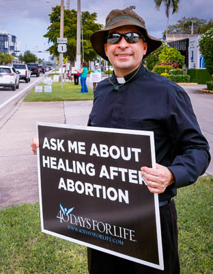 Father Jose Alfaro, pastor of St. John Neumann Parish in Miami, demonstrates against abortion with parishioners on U.S.1 Highway on Respect Life Sunday, Oct. 5, 2025.