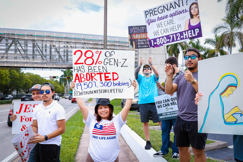 College students from Florida International University and Miami-Dade College hold pro-life signs as they demonstrate against abortion in the annual Life Chain across U.S.1 Highway on Respect Life Sunday, Oct. 5, 2025.