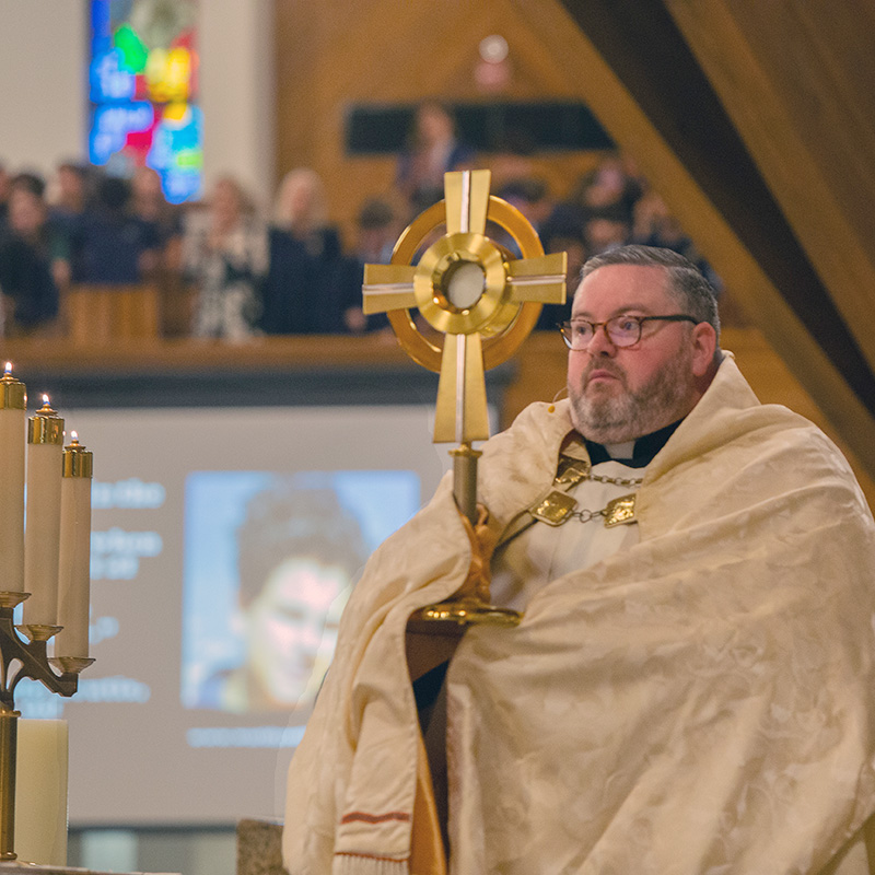 Father Ryan Saunders, pastor of St. David Church in Davie, exposes the Blessed Sacrament during a Holy Hour with Archdiocese of Miami middle school students, Oct. 10, 2025.