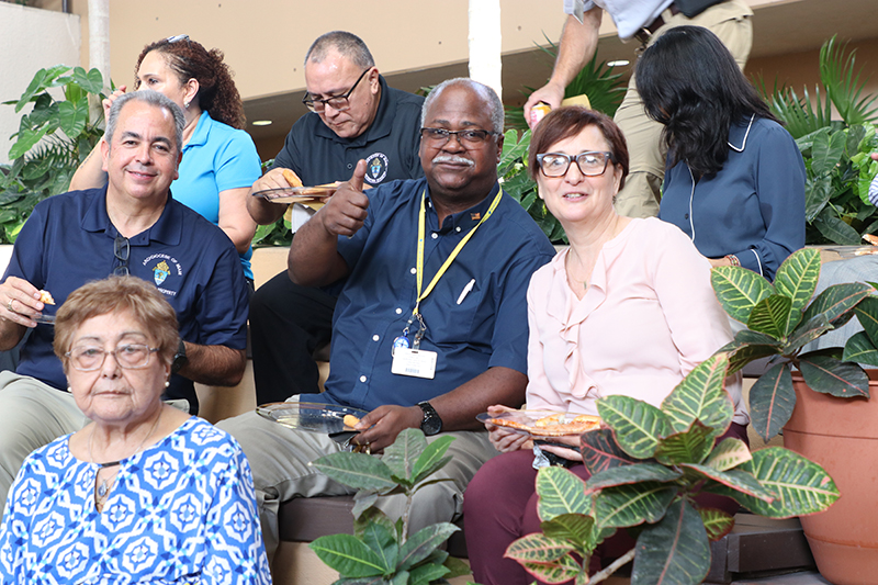 Pastoral Center staff and guests enjoy pizza during Archbishop Thomas Wenski’s 75th birthday party Oct. 20, 2025, at the Archdiocese of Miami Pastoral Center in Miami Shores.
