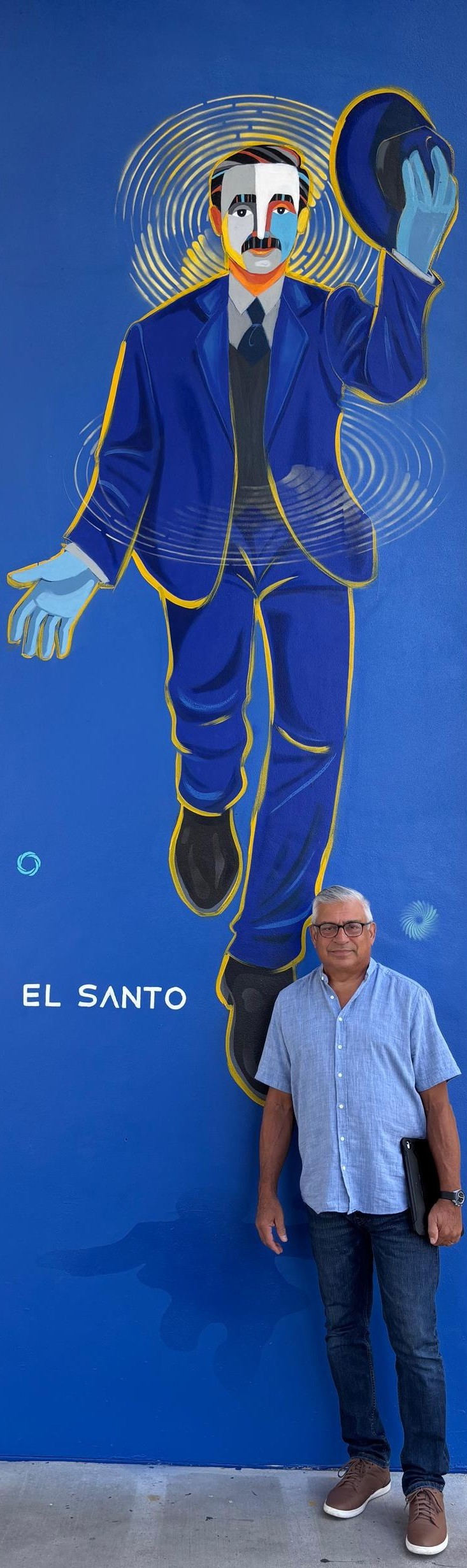 Parishioner Domingo Santana poses in front of the image of Blessed José Gregorio Hernández, known as "El Santo," located in St. Katharine Drexel Parish in Weston. Venezuelan artist Eduardo Sanabria created the image in homage to the new saint, who will be canonized on October 19, 2025.