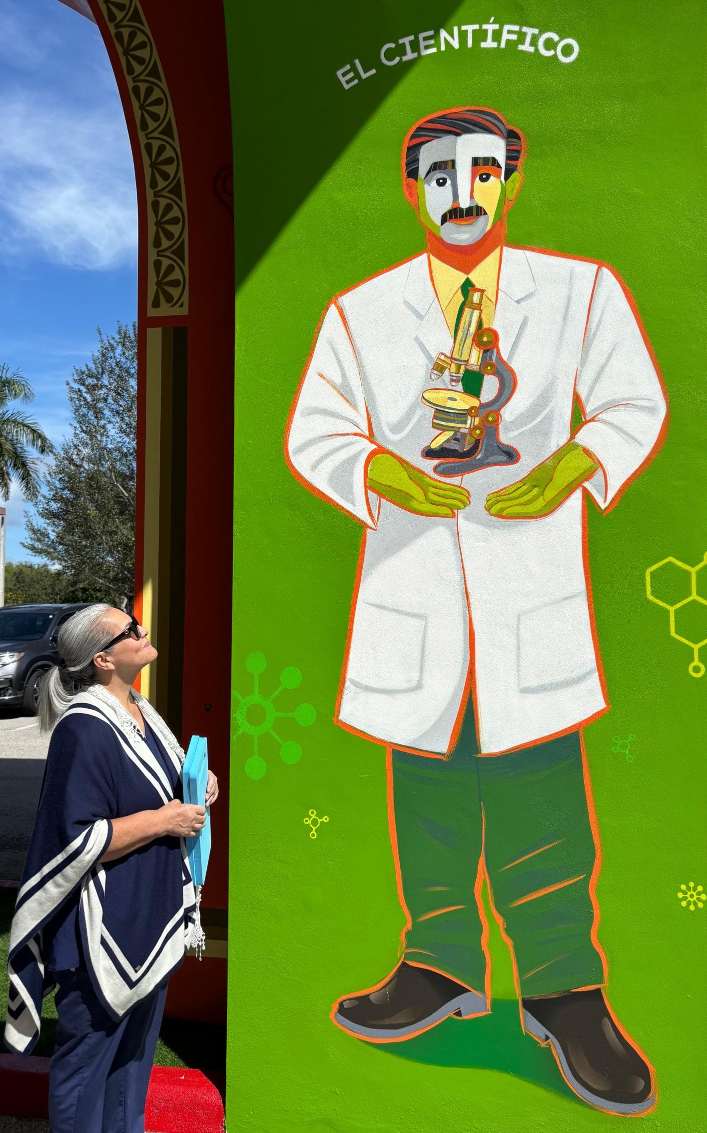 Rita Alsina, a parishioner at St. Katharine Drexel in Weston, closely examines an image of Blessed José Gregorio Hernández, known as "The Scientist," located in the parish. Venezuelan artist Eduardo Sanabria created the image in homage to the new saint, who will be canonized Oct. 19, 2025.