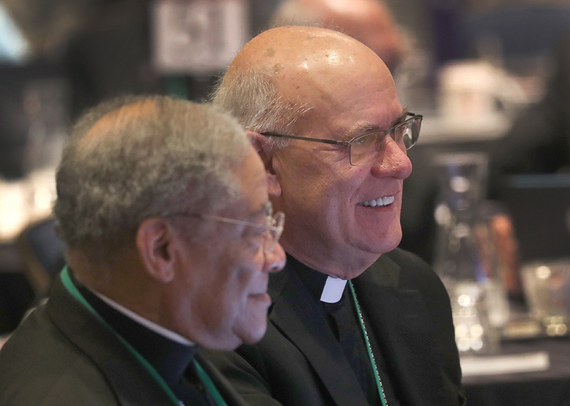 Bishop Kevin C. Rhoades of Fort Wayne-South Bend, Ind., smiles after being elected secretary of the U.S. Conference of Catholic Bishops during a Nov. 12, 2025, session of the fall general assembly of the USCCB in Baltimore. At left is retired Chicago Auxiliary Bishop Joseph N. Perry.