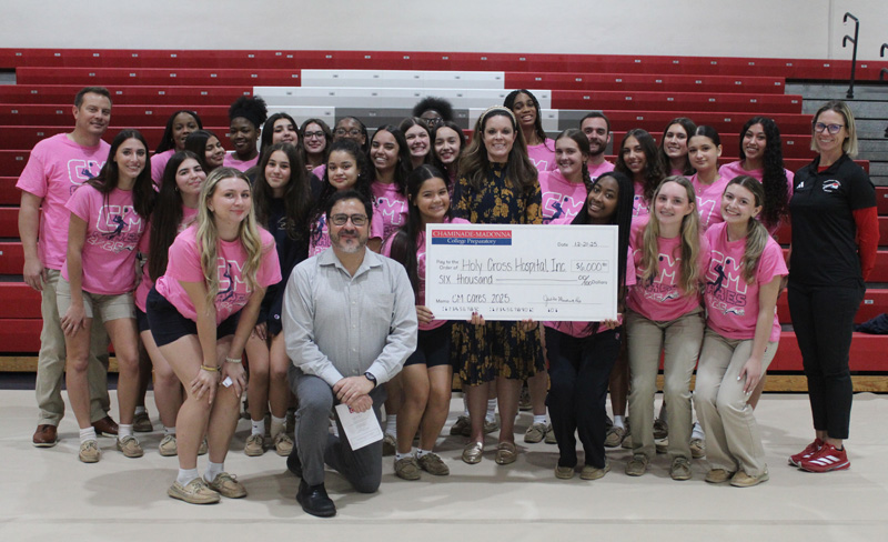 The Chaminade-Madonna College Prep Girls Volleyball team presented a $ 6,000 check to Holy Cross Health's Michael and Diane Bienes Comprehensive Cancer Center during the Chaminade-Madonna Thanksgiving Prayer Service on Nov. 21, 2025. In the photo with the volleyball team is Coach Jason Johnson, Chaminade-Madonna Head Girls Volleyball Coach (far left, last row); Caytie Lagrange, Chaminade-Madonna Women’s Athletic Director (far right, last row); Jorge Gitler, Executive Director of the Michael and Dianne Bienes Comprehensive Cancer Center (kneeling center); and Brittany Henson, Holy Cross Health Development Officer (standing center).