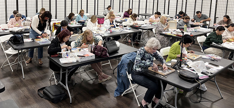 Los participantes del taller de Arte Sacro en la parroquia Our Lady of Guadalupe trabajan con un fondo de música sacra y un ambiente de oración durante una clase en octubre de 2025.