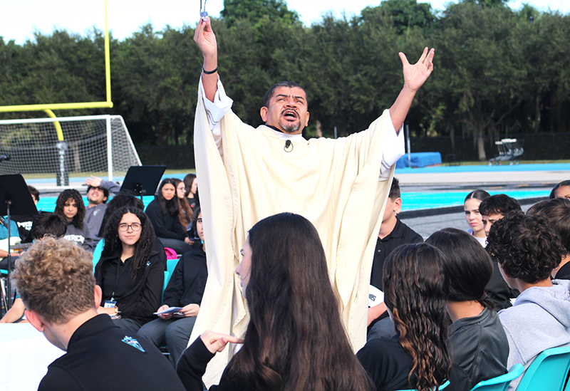 Father Edivaldo da Silva Oliveira, chaplain at Archbishop Edward McCarthy High School, delivers his homily during a Mass Nov. 13, 2025, at the school's football stadium. After the Mass, McCarthy High was announced as a 2025 National Blue Ribbon School, the only Catholic high school in Florida to receive the distinction this year.