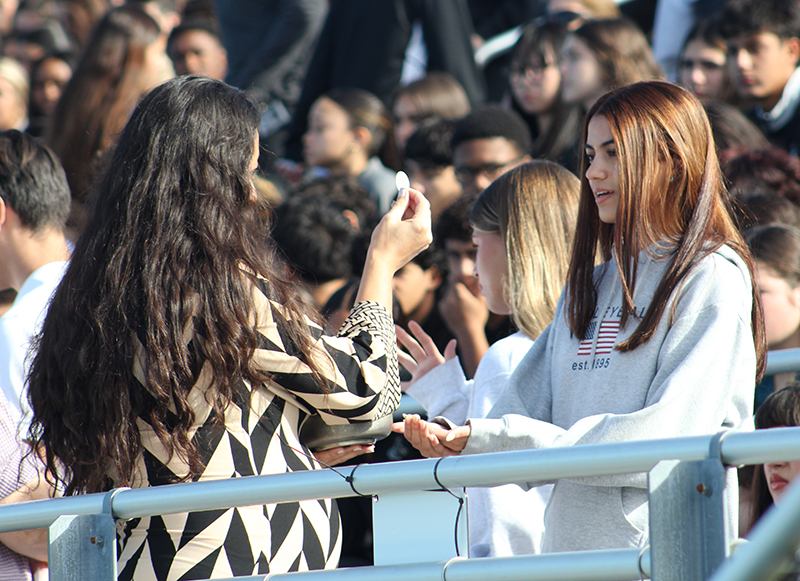 A faculty member at Archbishop Edward McCarthy High distributes Communion during a Mass Nov. 13, 2025, at the school's football stadium. After the Mass, McCarthy High was announced as a 2025 National Blue Ribbon School, the only Catholic high school in Florida to receive the distinction this year.