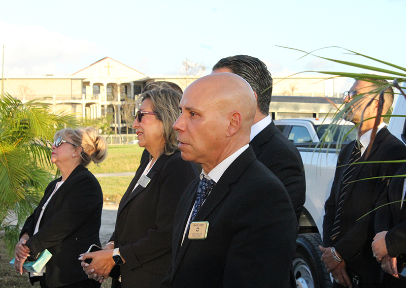Manuel Perez (center) and other staff members of Our Lady of Mercy Catholic Cemetery in Doral listen during Archbishop Thomas Wenski’s blessing of the completed Resurrection Mausoleum Complex Nov. 14, 2025.