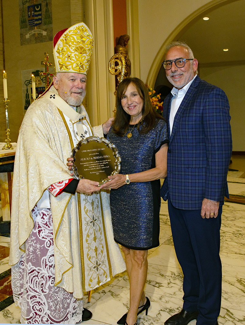 Archbishop Thomas Wenski presents Alicio and Nirma Piña, of Our Lady of the Lakes Church in Miami Lakes, with the 2025 One in Faith award during the annual Thanks-for-Giving Mass hosted by the archdiocesan Office of Development to honor those who contribute faithfully to the ABCD. The Mass was celebrated Nov. 22, 2025 at St. Mary Cathedral in Miami.