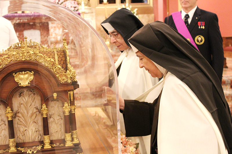 Carmelite Sisters Gabriela and Mary Elizabeth, who teach at St. Theresa School in Coral Gables, venerate the relics of St. Therese of Lisieux, “The Little Flower,” at the Church of the Little Flower, also in Coral Gables Dec. 2, 2025.