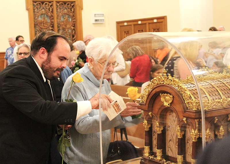 Seminarian Erich Vazquez venerates the relics of St. Therese of Lisieux, “The Little Flower,” at the Church of the Little Flower in Coral Gables Dec. 2, 2025. By touching an object to the first-class relic, he creates a third-class relic.