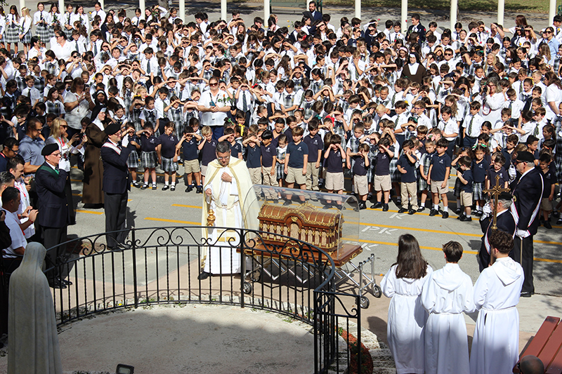 With students from St. Theresa School in Coral Gables in attendance, Father Manny Alvarez, pastor of the Church of the Little Flower next door, blesses the relics of St. Therese of Lisieux upon their arrival at the school Dec. 2, 2025. St. Theresa School is the first stop on the relics’ tour of the Archdiocese of Miami.