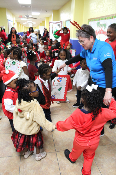 Staff from Las Madrinas Insurance, Lourdes Academy, and Catholic Charities Notre Dame Child Development Center dance with children during a holiday event on Dec. 16, 2025. On that day, over 200 children at Notre Dame received gifts donated by the Lourdes Academy community.