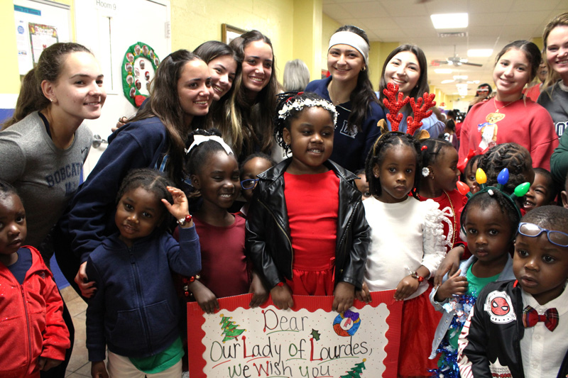 Children from Catholic Charities Notre Dame Child Development Center pose with students from Lourdes Academy during a holiday event on Dec. 16, 2025. On that day, over 200 children at Notre Dame received gifts donated by the Lourdes Academy community.
