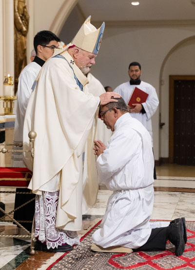 Miami Archbishop Thomas Wenski lays hands on Gustavo Adolfo Roversi during the diaconate ordination which took place at St. Mary Cathedral, Miami, on Dec. 13, 2025.