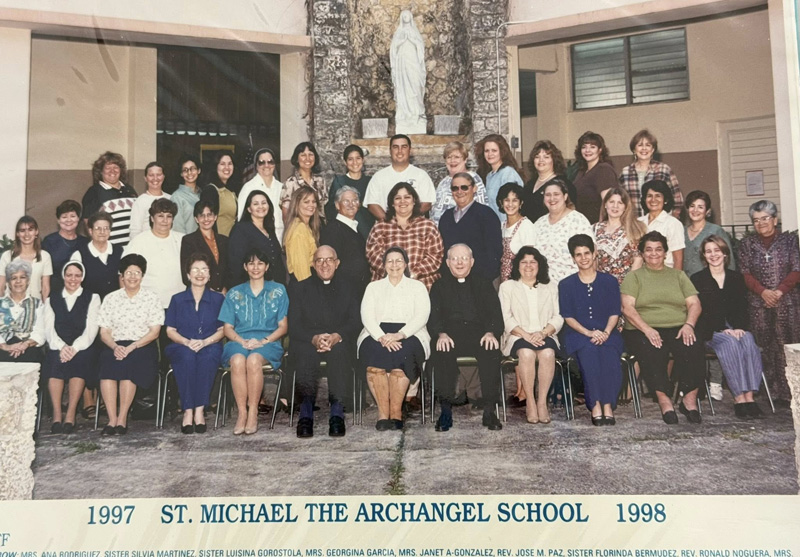 Sister Florinda Bermudez, RA, former teacher and principal of St. Michael the Archangel School, Miami, sits center in a yearbook photo taken for the 1997-1998 academic year along with faculty and priests.