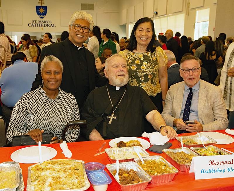 Archbishop Thomas Wenski and other guests enjoy the multicultural foods and folkloric dances from the various ethnic groups after the annual Migration Mass celebrated Jan. 11, 2026, on the feast of the Baptism of the Lord, at St. Mary Cathedral. From left, Myrian Mezadieu, COO of Catholic Legal Services; Father Jesus Medina, archdiocesan director of the Ministry to Cultural Groups; Archbishop Wenski; Janet Macasero, member of the Filipino apostolate and Randy McGrorty, CEO and co-founder of Catholic Legal Services.