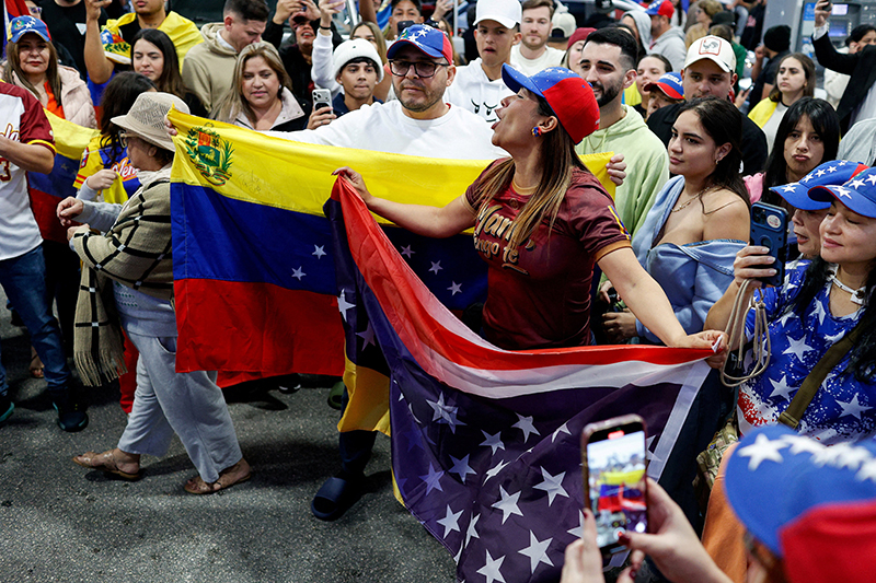 People hold Venezuelan and U.S. flags on the streets of Miami Jan. 3, 2026, as they react to the news after U.S. President Donald Trump said the U.S. has struck Venezuela and captured its President Nicolas Maduro.