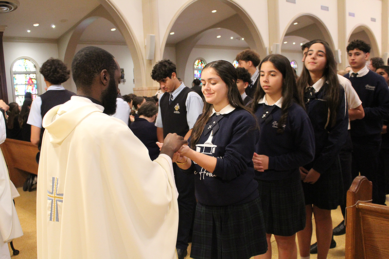Students from Immaculate Conception School in Hialeah receive Communion from Father Fenly Saint-Jean, pastor of St. James Parish in North Miami, during the fourth annual All Schools Mass on Jan. 26, 2026 celebrated at St. Mary Cathedral, Miami, in honor of Catholic Schools Week.