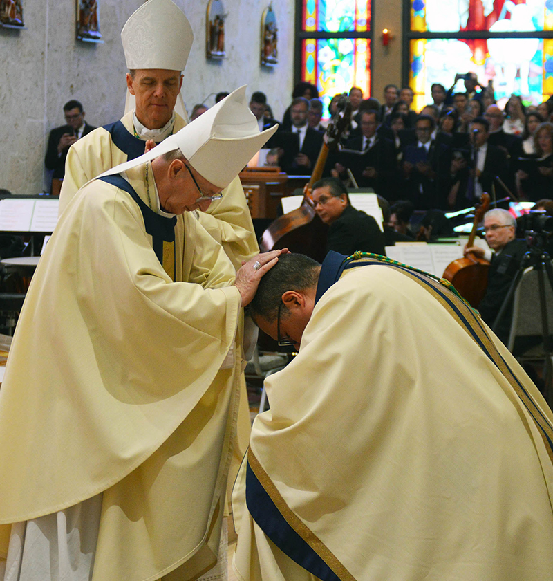 Orlando Bishop John Noonan prays silently during the laying on of hands for Bishop-elect Manuel de Jes&uacute;s Rodr&iacute;guez as Bishop Stephen Parkes of Savannah stands in wait.