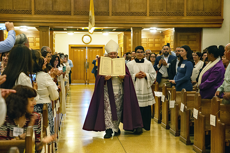 Archbishop Thomas Wenski displays Book of the Elect signatures to congregation. 947 catechumens from 110 parishes signed the Book of the Elect during two ceremonies Feb. 22 at St. Mary's Cathedral, Miami.