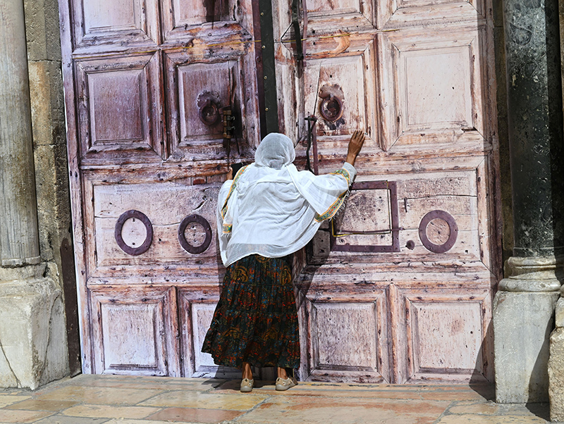 An Ethiopian Christian woman prays at the locked doors of the Church of the Holy Sepulcher in the Old City of Jerusalem March 4, 2026, on day five of the U.S.-Israel war with Iran. The church and other religious sites as well as stores were locked shut by order of the Israeli government as Iranian ballistic missiles were fired at Israel.