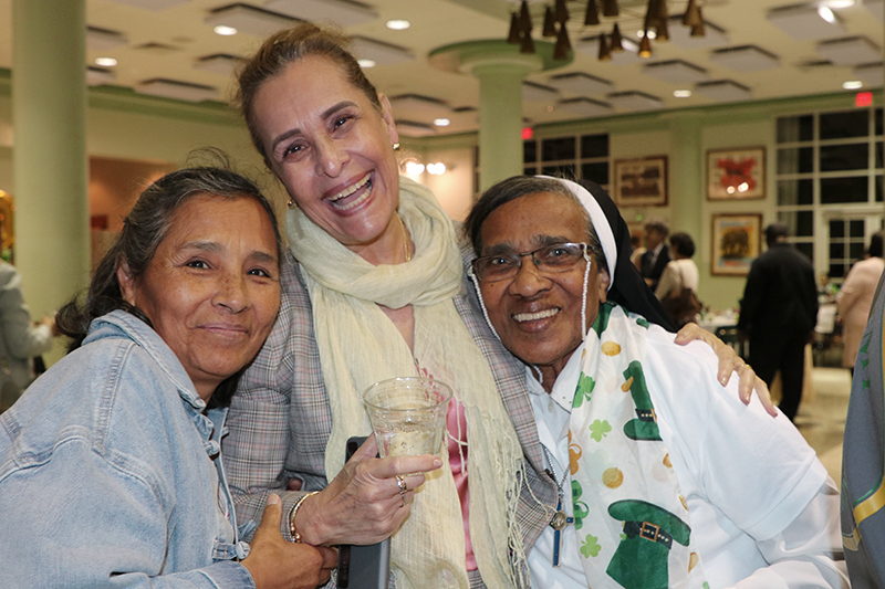 From left, parishioners Guadalupe Mendoza and Isaura Uriel of St. Patrick Parish in Miami Beach pose with Sister Claudina Sanz, of the Oblate Sisters of Providence, catechist and youth minister at the church, during the reception after the Mass commemorating the 100th anniversary of the parish on St. Patrick’s Day, March 17, 2026.