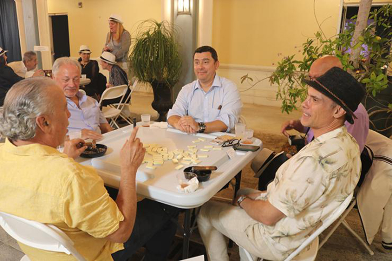 Some attendees at “Havana Nights,” a fundraising event for Catholic Charities’ Unaccompanied Minors Program, enjoy playing dominoes and chatting March 26, 2026, in the courtyard of St. Mary Cathedral in Miami.