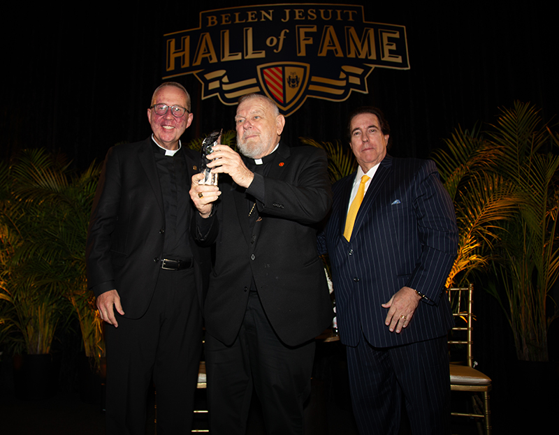Archbishop Thomas Wenski receives the Hall of Fame award from Jesuit Father Guillermo “Willie” García-Tuñón, president of Belen Jesuit, and Peter Montadas, Hall of Fame chairman, during the Belen Jesuit Preparatory School Hall of Fame induction ceremony March 21, 2026.