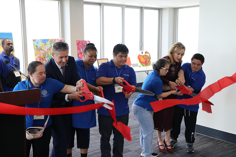 With large scissors in hand, artists from the Marian Center School and Services in Miami Gardens Adult Day Training (ADT) Program cut the ribbon to inaugurate the Agency for Persons with Disabilities (APD) Art Show, hosted at the 22nd floor of the Florida State Capitol in Tallahassee, March 10, 2026. Also cutting the ribbon were Bob Asztalos, director of APD, and Representative Allison Tant (District 9).