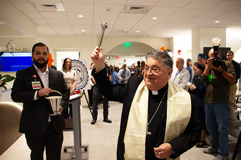 Archdiocese of Miami Auxiliary Bishop Enrique Delgado (center) blesses the revamped surgical lobby at HCA Florida Mercy Hospital in Miami at the lobby’s April 21 dedication. The surgical waiting room honors the hospital’s sponsors, the Sisters of St. Joseph of St. Augustine, as well as Sister Elizabeth Worley, Archdiocese of Miami chancellor for administration and chief operating officer (COO) and former chair of the Mercy Hospital Board.