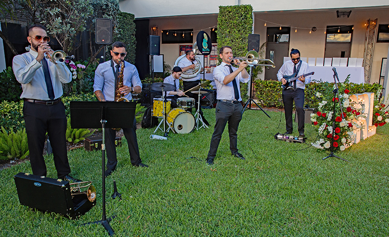The Bop Shop brass band performs in the courtyard of St. Rose of Lima School as caterers serve hors d’oeuvres during a gala celebration marking the kickoff of the school’s 75th anniversary celebration in Miami Shores April 25, 2026.