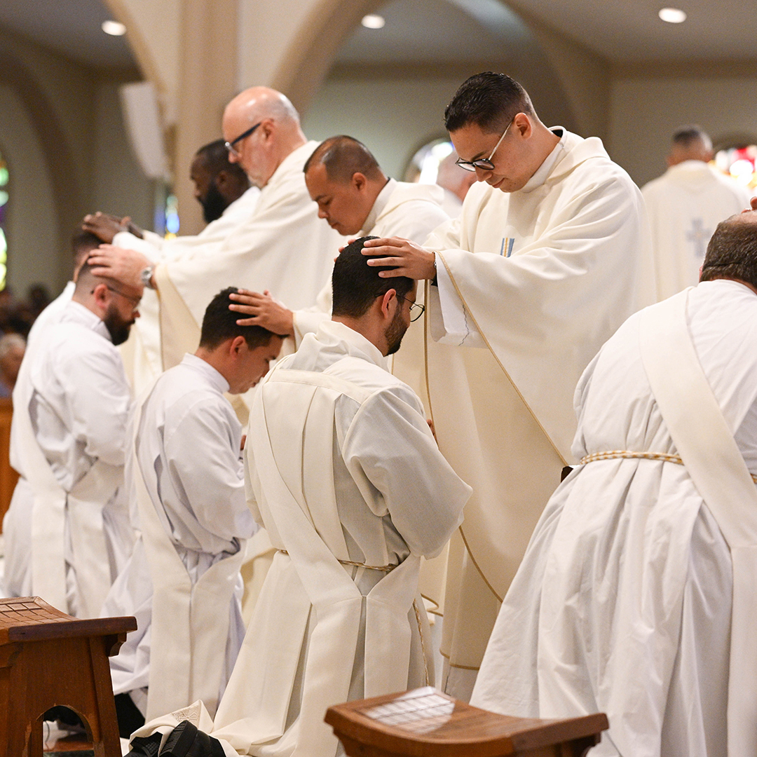 Clérigos de Miami oran sobre los recién ordenados sacerdotes de la Arquidiócesis de Miami el 9 de mayo en la Catedral St. Mary de Miami.
