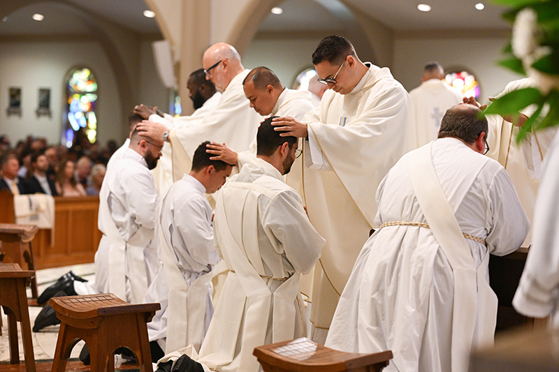 Miami clergy pray over the newly ordained priests of the Archdiocese of Miami May 9 at St. Mary's Cathedral in Miami.