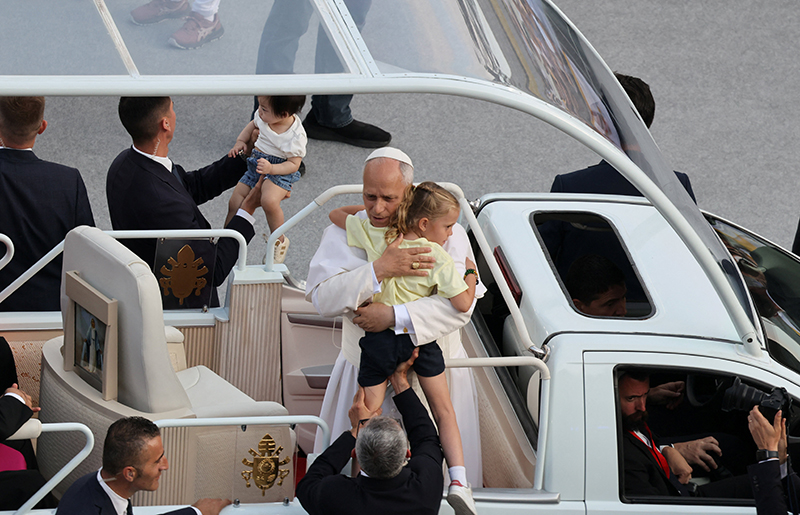 Pope Leo XIV carries five-year-old In&eacute;s Rivero as he attends a prayer vigil at the Lluis Companys Olympic Stadium, during his apostolic journey, in Barcelona, Spain, June 9, 2026. In&eacute;s tried to remove the rosary from her wrist so she could present it to the pope, but despite her efforts, it would not come off completely. "He told her not to worry," her mother, Fernanda Rivero, recalled. "And then he gave her one of his own." (OSV News photo/Nacho Doce, Reuters)
