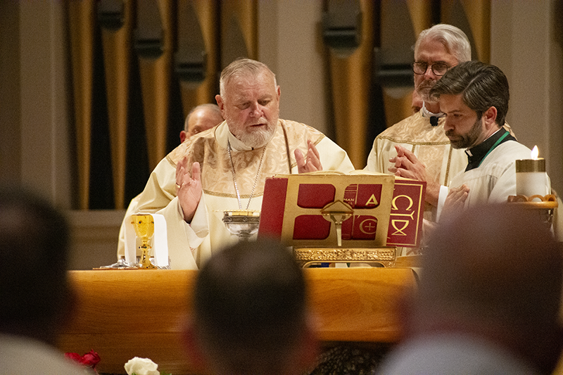 Archbishop Thomas Wenski of Miami prays during the June 11 Mass at the Basilica of the National Shrine of Mary, Queen of the Universe in Orlando as Archbishop Paul S. Coakley of Oklahoma City, president of the U.S. Conference of Catholic Bishops, stands behind him. During the liturgy, U.S. bishops consecrated the United States to the Sacred Heart of Jesus.