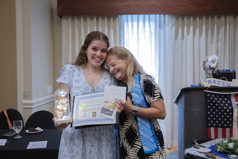 Fabiola Sanchez-De Armas, right, president of the Miami Archdiocesan Council of Catholic Women, congratulates Danielle Ellie after presenting her with the 2026 Golden Rose Award during the organization's 68th Annual Convention in Miami.