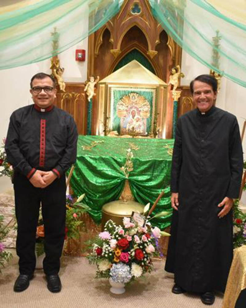 Father Ra&uacute;l C&aacute;rdenas, pastor, left, and Father John Mericantante, pastor emeritus, stand next to the 16th century icon of Our Lady of Bethlehem at St. Mary Church in Pahokee.