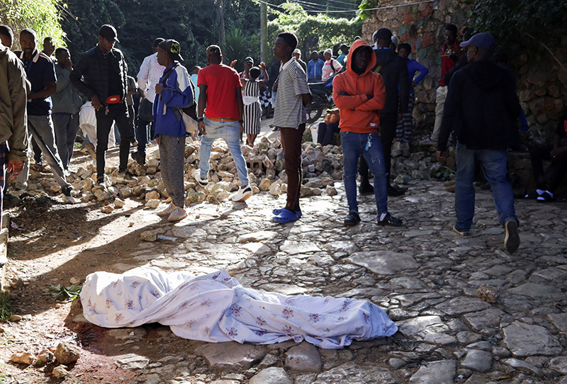 People gather near the covered body of a person in Kenscoff, Haiti, on the outskirts of Port-au-Prince, killed during an overnight raid by an armed gang. A powerful gang coalition attacked a once peaceful farming community nestled in the hills above Haiti’s capital late Aug. 23, killing at least 47 and kidnapping 50. (OSV News photo/Fildor Pq Egeder, Reuters)