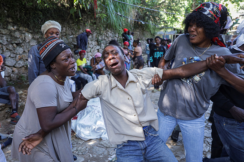 A man mourns next to the covered body of a person in Kenscoff, Haiti, on the outskirts of Port-au-Prince, Aug. 24, 2026, killed after a fatal overnight raid by an armed gang. A powerful gang coalition attacked a once peaceful farming community nestled in the hills above Haiti’s capital late Aug. 23, killing at least 47 and kidnapping 50. (OSV News photo/Patrice Noel, Reuters)
