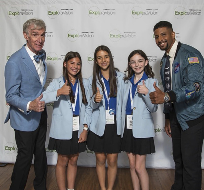At center, Sam Dominguez, Clementina Martinez-Christensen and Adriana Icaza from St. Thomas the Apostle School in Miami pose with celebrities Bill Nye the Science Guy (far left) and Justin “Mr. Fascinate” Shaifer (far right) as winners of the 2026 Toshiba/NSTA ExploraVision Competition. The St. Thomas team won second place in the Grade 4-6 category for their “Smart Sock” invention idea and met the celebrities during the celebratory trip to Washington, D.C. June 3-5, 2026.