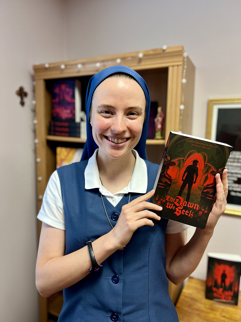 Sister Allison Regina Gliot stands in her office at the Pauline Books and Media Center in Miami June 2026, holding “The Dawn We Seek,” her last book in her vampire trilogy.