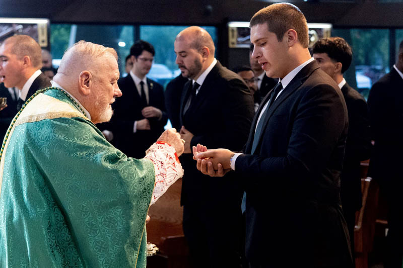 Archbishop Thomas Wenski, left, distributes the Eucharist to seminarians enrolled at St. John Vianney College Seminary in Miami, who gathered Aug. 1, 2026, for a Saturday Vigil Mass at St. Hugh Parish in Coconut Grove. Attending the Mass was part of their summer convocation and orientation process before the start of the 2026-2027 academic year.