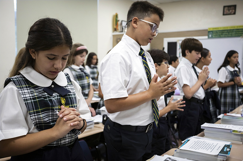 Mila Enrizo, left, prays with her classmates on the first day of school at St. Theresa Catholic School in Coral Gables on Aug. 11, 2026.