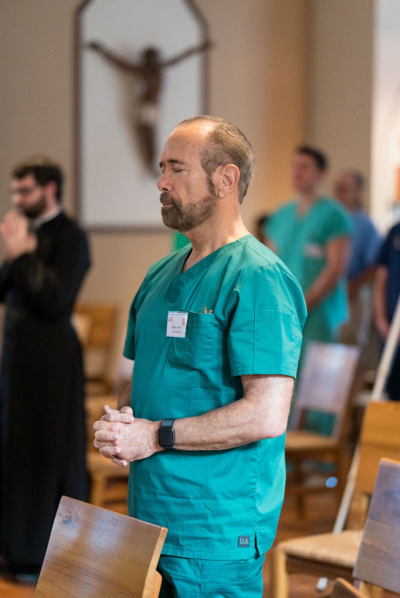 A member of the U.S volunteer medical team sponsored by the Cuban Association of the Order of Malta attends morning Mass in 2025 during a week-long clinic in the Dominican Republic. Team members had an opportunity to gather for prayer at the start and finish of each day.