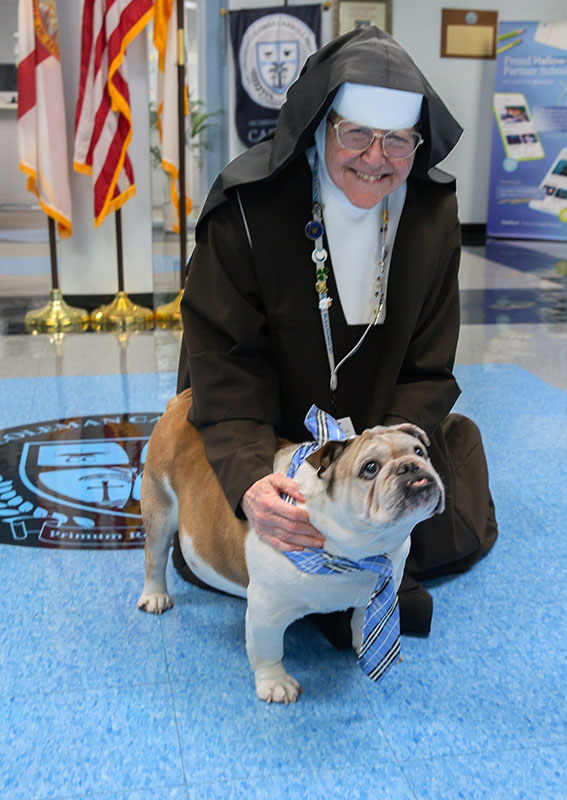Carmelite Sister Margaret Ann Laechelin, principal of Archbishop Coleman F. Carroll High in Miami, hugs Archie, beloved school mascot, on Aug. 27, 2026.